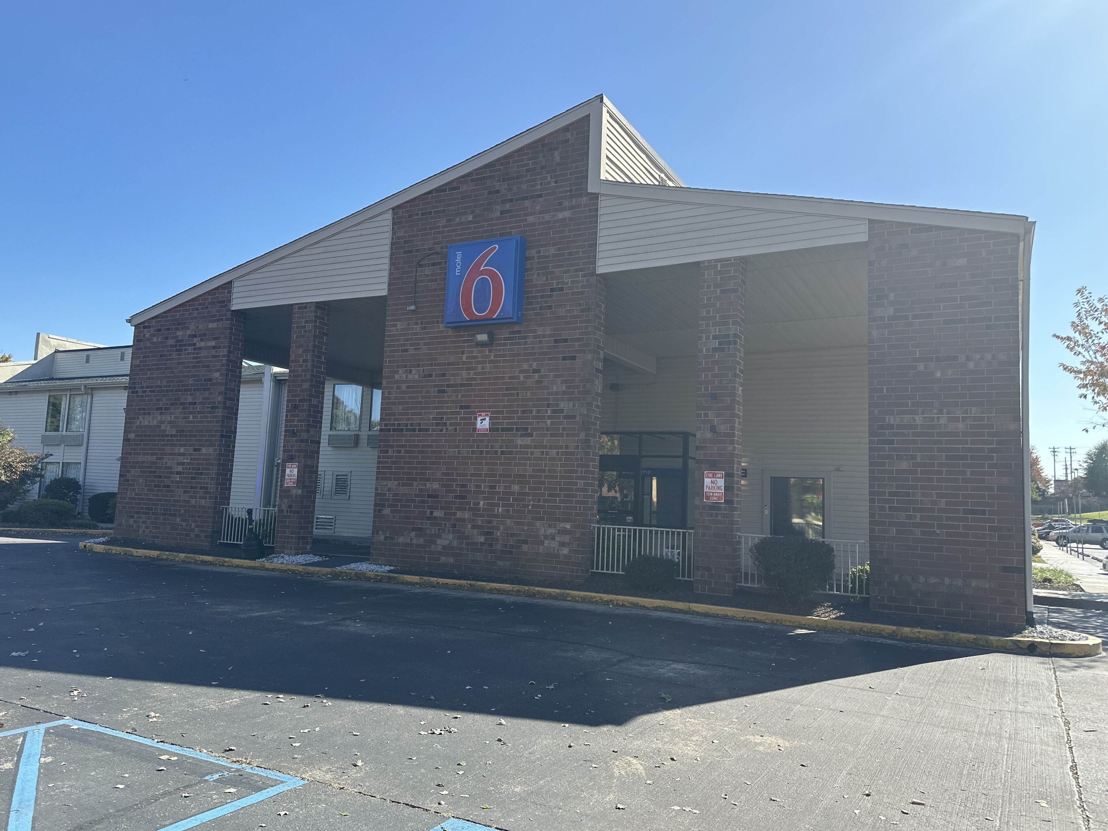A motel with a prominent '6' sign, a brick facade, and a covered entrance.