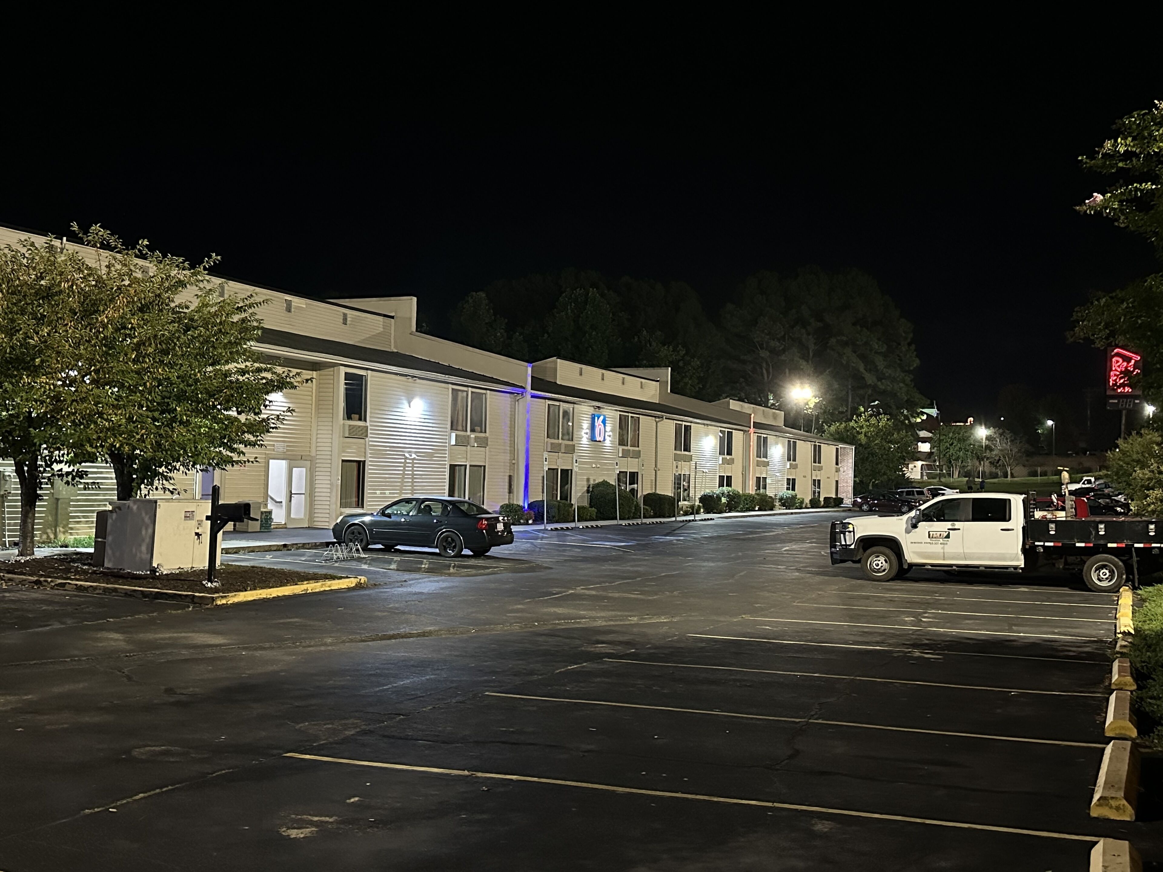 A parking lot with a building that has a sign indicating it is a motel.