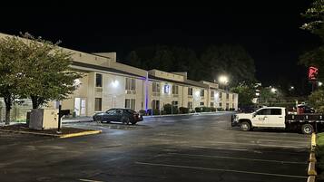 A parking lot with a building that has a sign indicating it is a motel.