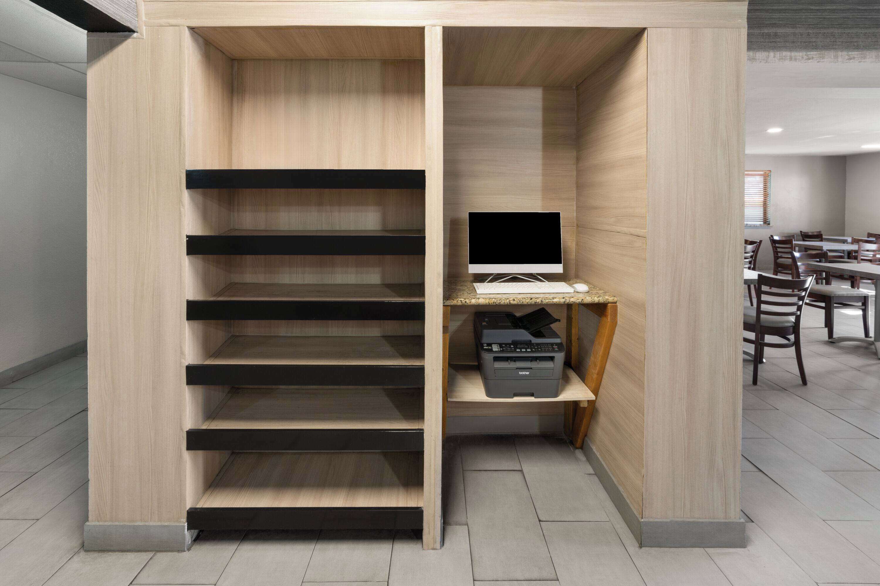 A modern office space with a built-in desk, computer, and printer.
