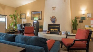 A hotel lobby with a fireplace, seating area, and a reception desk.