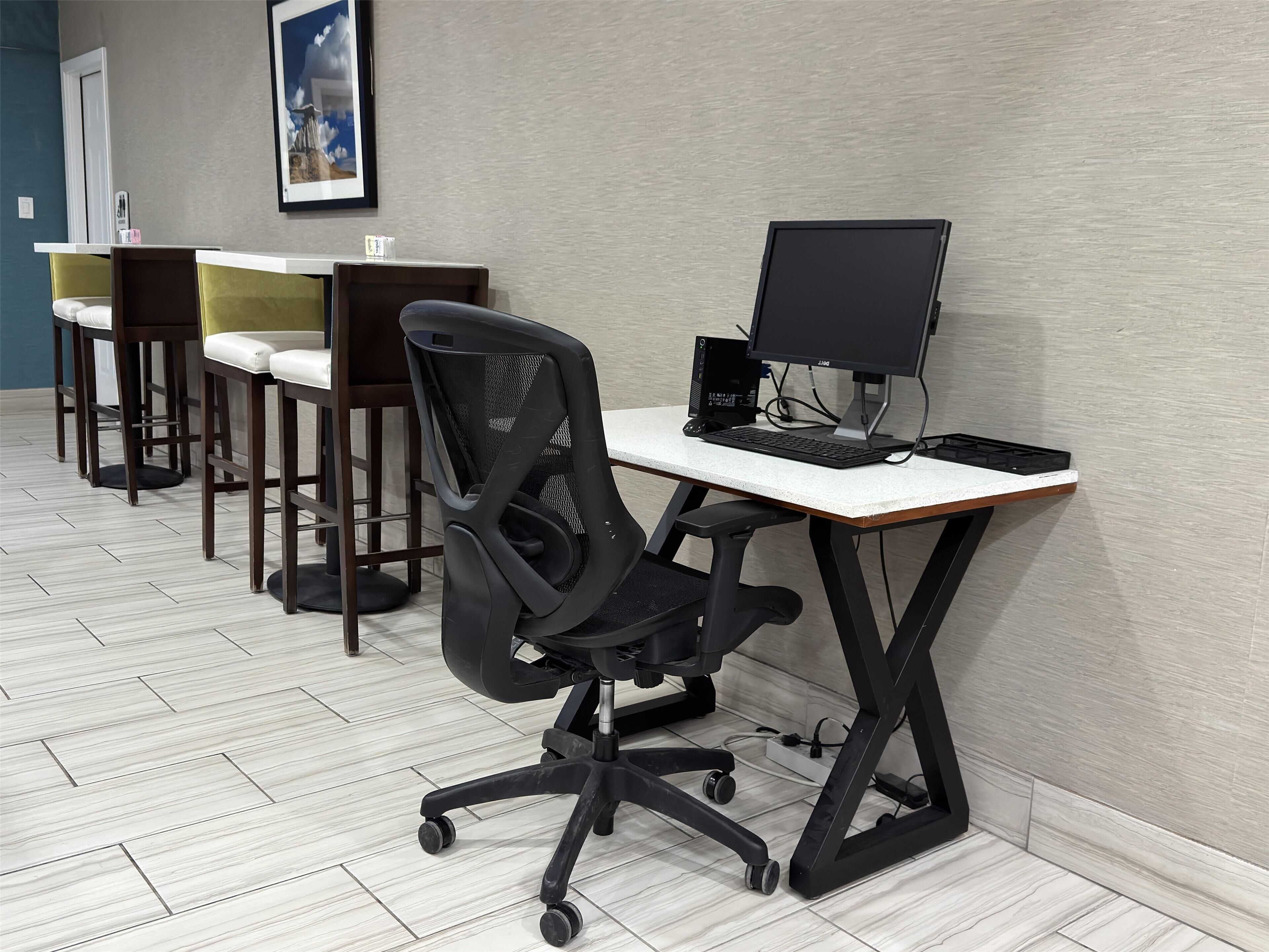 Un espacio de oficina moderno con escritorio, silla y equipo informático.