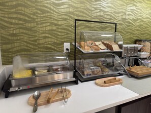 A breakfast buffet with various food items and a coffee machine. - SureStay Plus by Best Western Alamogordo White Sands (Alamogordo)