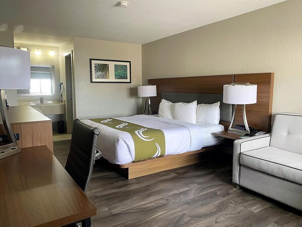 A hotel room with a bed, bedside lamps, a desk, and a chair. - SureStay Plus by Best Western Alamogordo White Sands (Alamogordo)