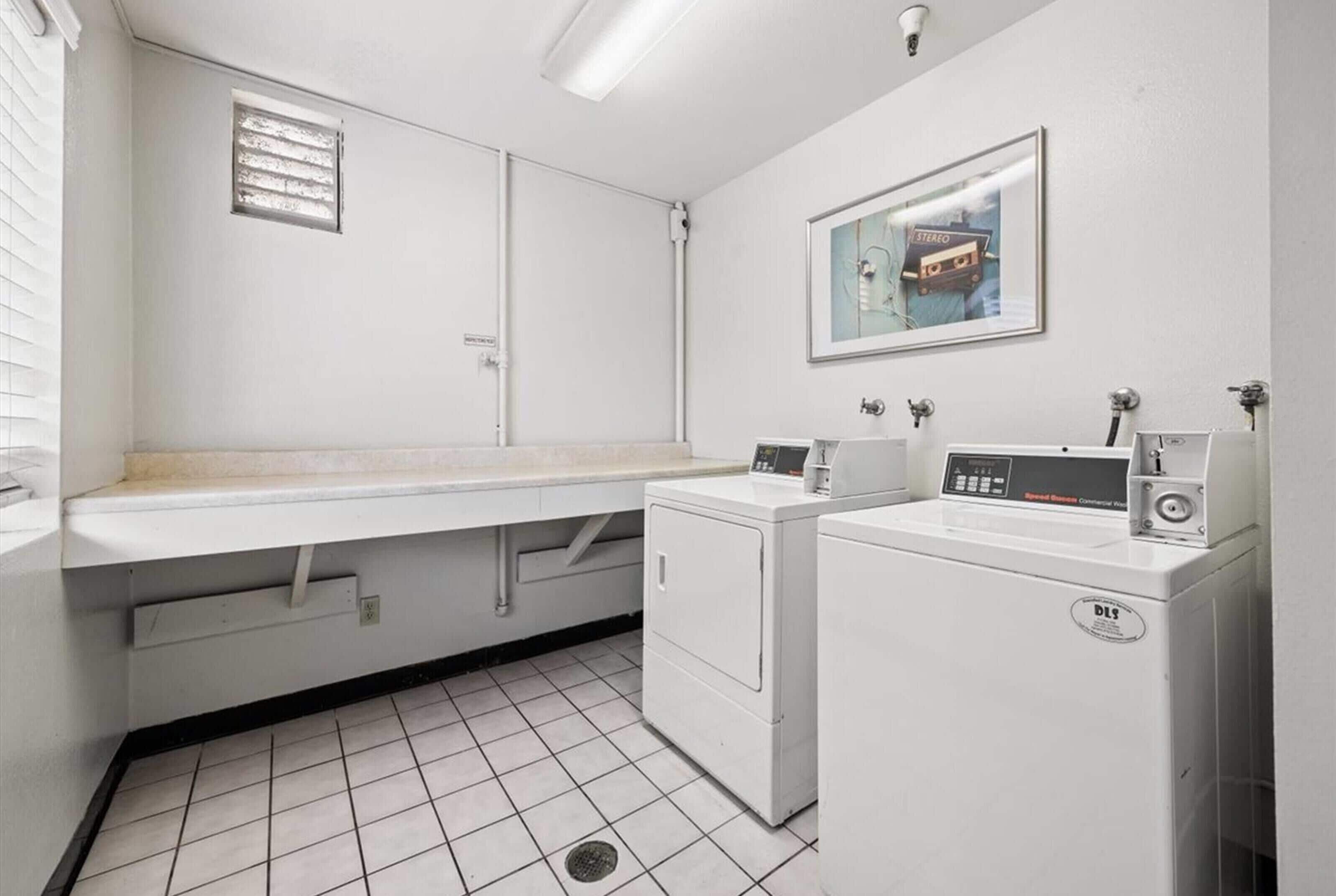 Un cuarto de lavandería con lavadora, secadora y una encimera con lavabo.