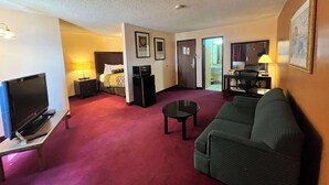 A hotel room with a TV, a bed, a desk, a chair, and a sofa. - Motel 6 Deming, NM (Deming)