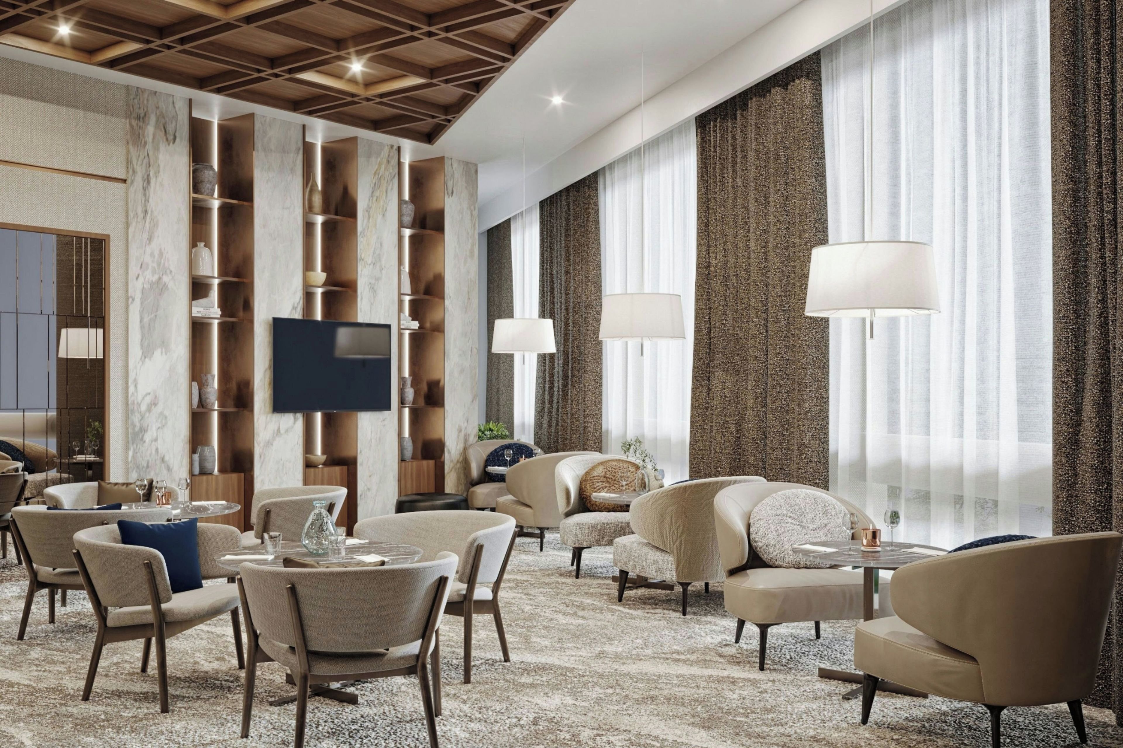 A modern hotel lobby with a high ceiling, marble walls, and a seating area with sofas and chairs.