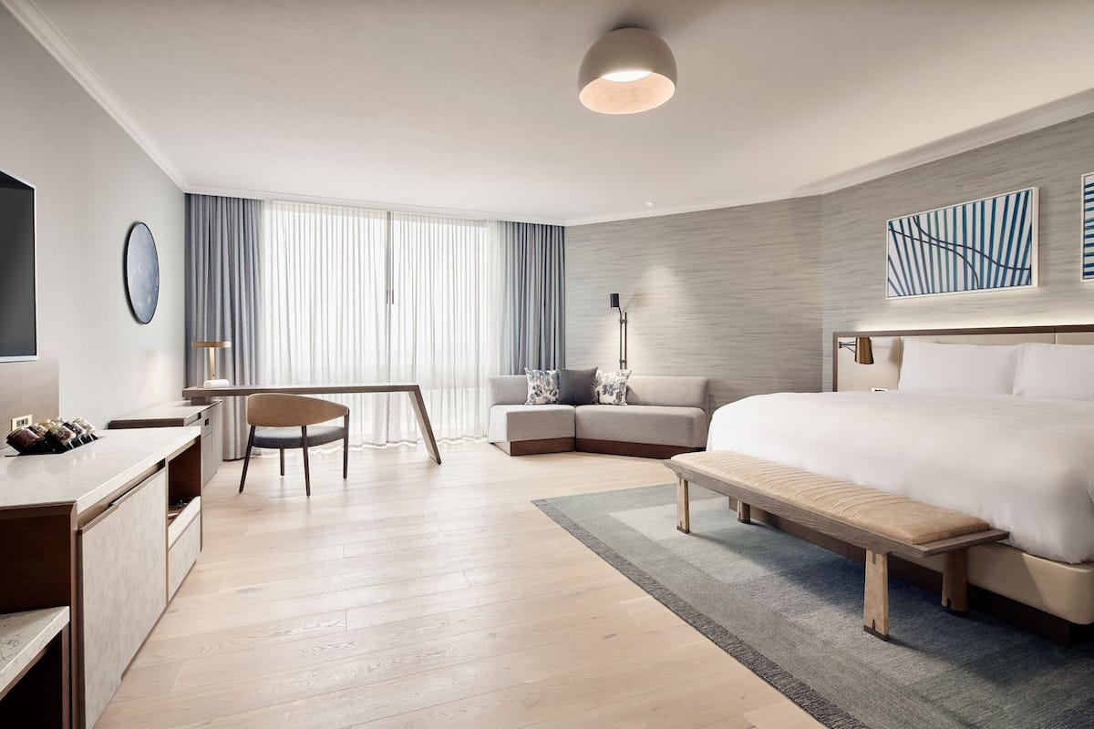 Een moderne hotelkamer met een groot bed, een bureau, een stoel en een bank.