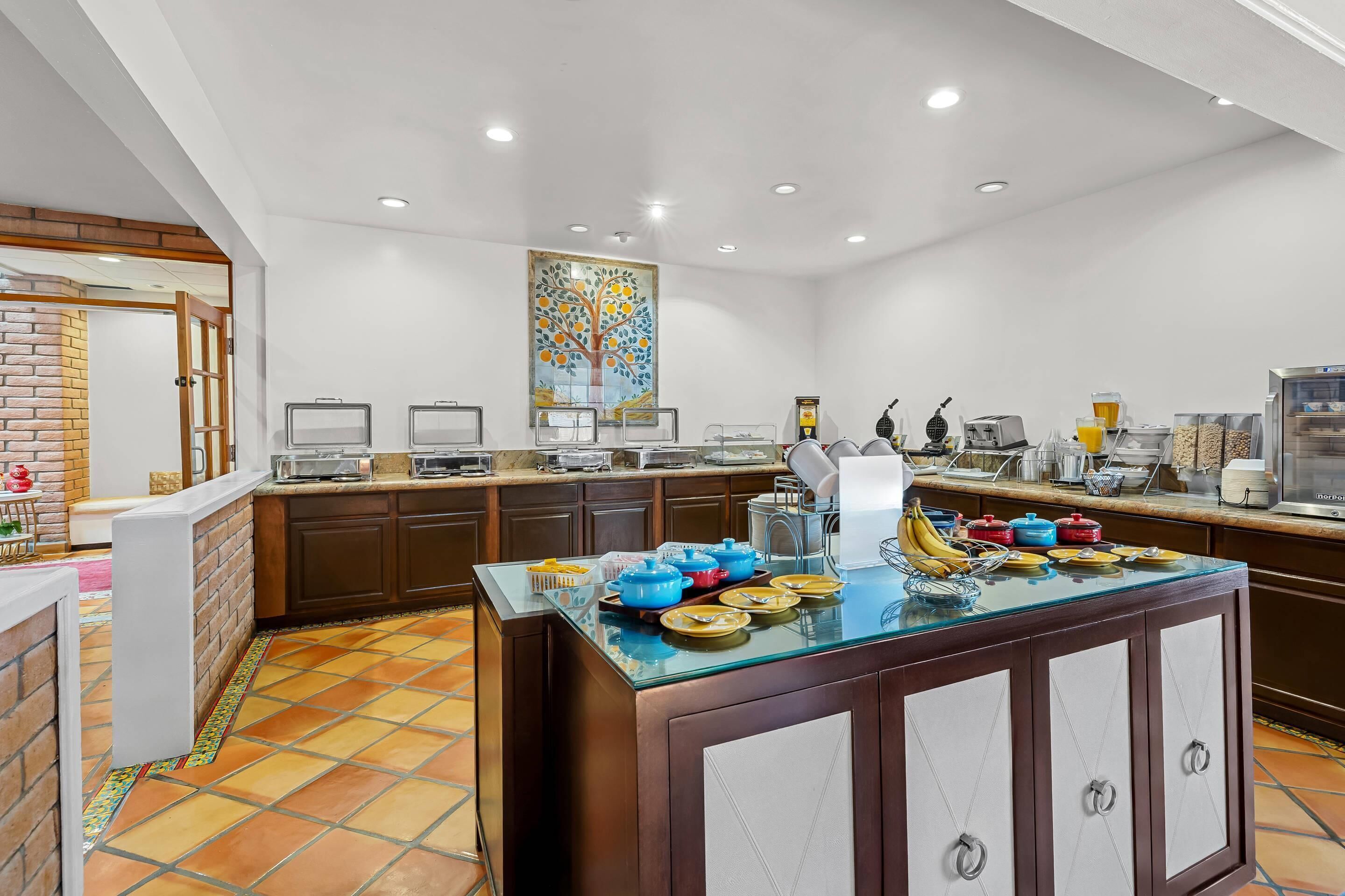 A modern kitchen with a central island, built-in appliances, and a decorative wall piece.