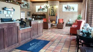 A lobby with a reception desk, seating area, and a fireplace.