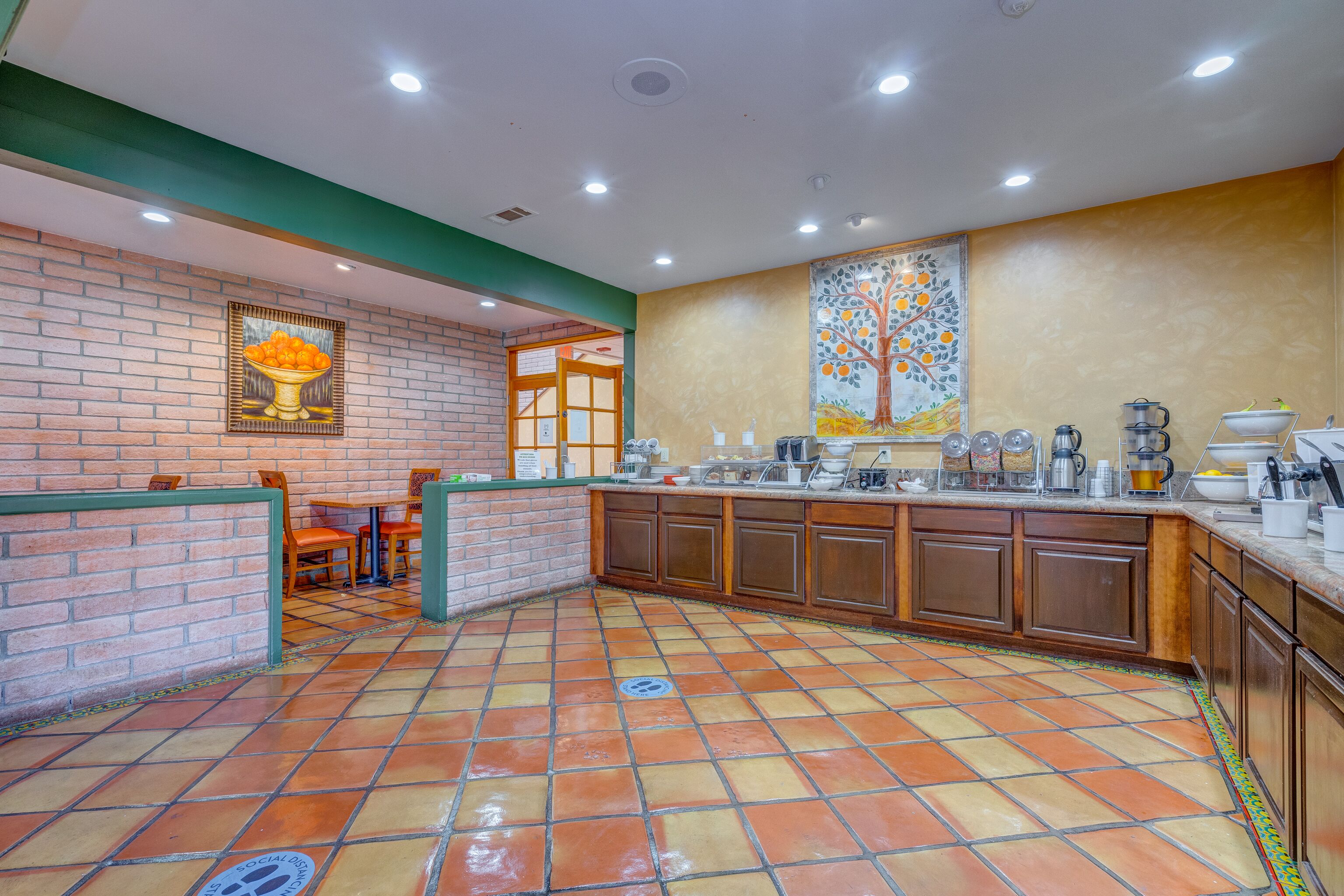 A restaurant with a brick wall, tiled floor, and wooden cabinets.