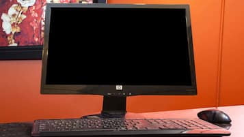 A desktop computer with a keyboard and mouse on a granite countertop.