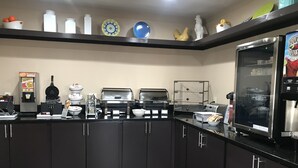 Eine Küchenzeile mit Kaffeemaschine, Toaster und Kühlschrank.