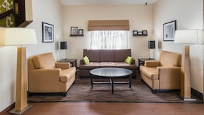 Una sala de estar moderna con un sofá, dos sillones, una mesita de centro y una alfombra estampada.