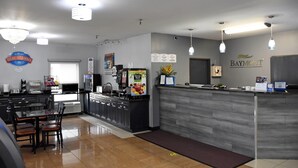 A modern breakfast area with a counter, seating, and a sign for breakfast. - Baymont by Wyndham Morton (Morton)