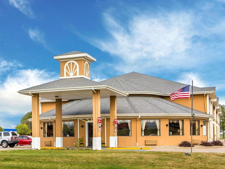 A building with a flat roof, a central tower with a decorative design, and an American flag.