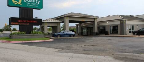 A hotel with a sign for 'Quality Inn & Suites by Choice Hotels' and a digital display indicating 'TRUCK PARKING.'