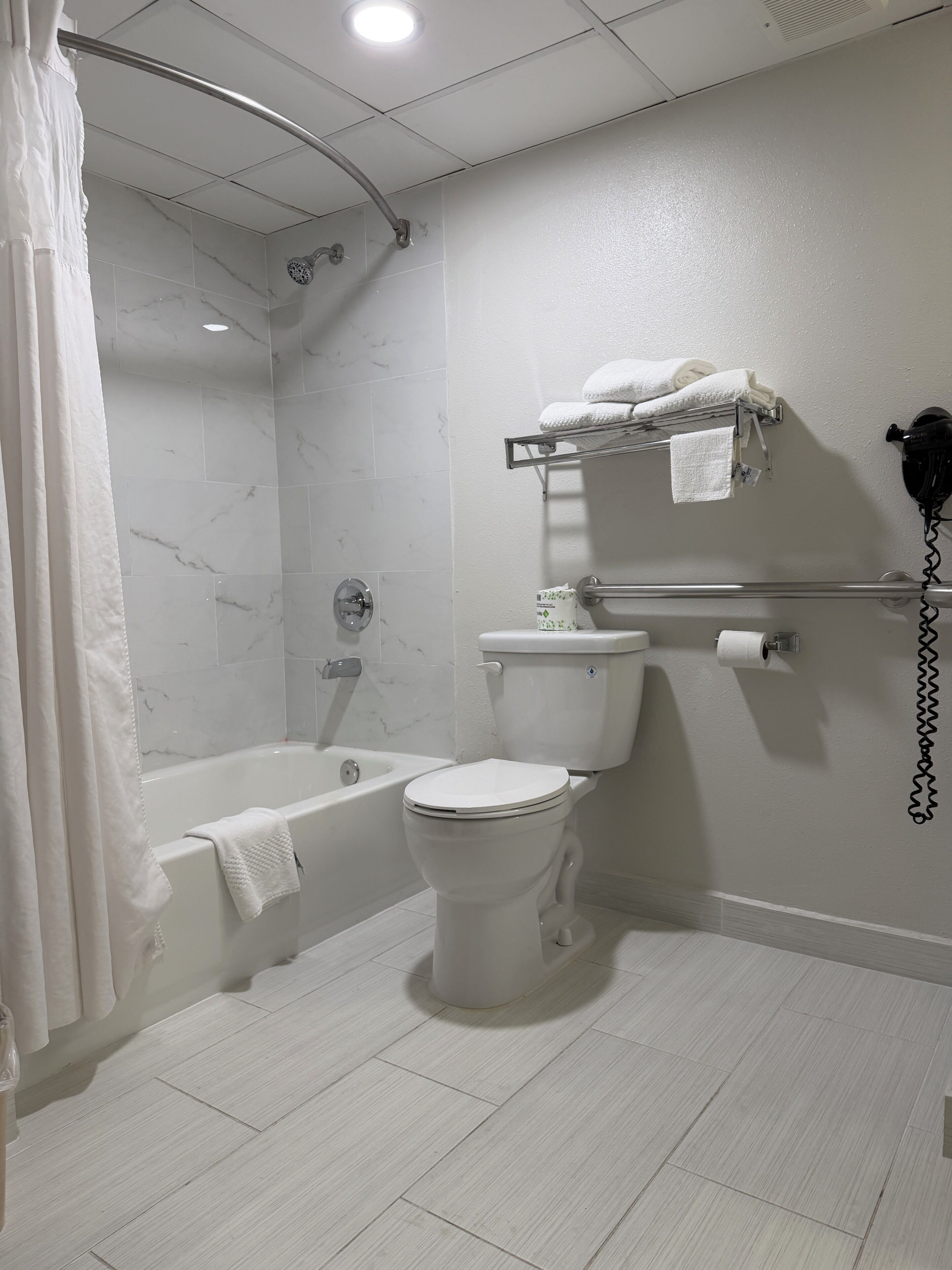 A bathroom with a bathtub, toilet, and shower.