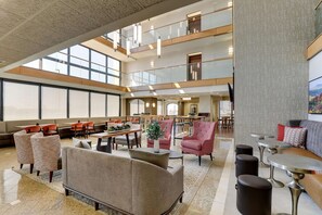 A spacious lobby with high ceilings, multiple seating areas, and large windows allowing natural light. - Drury Inn & Suites Marion (Marion)