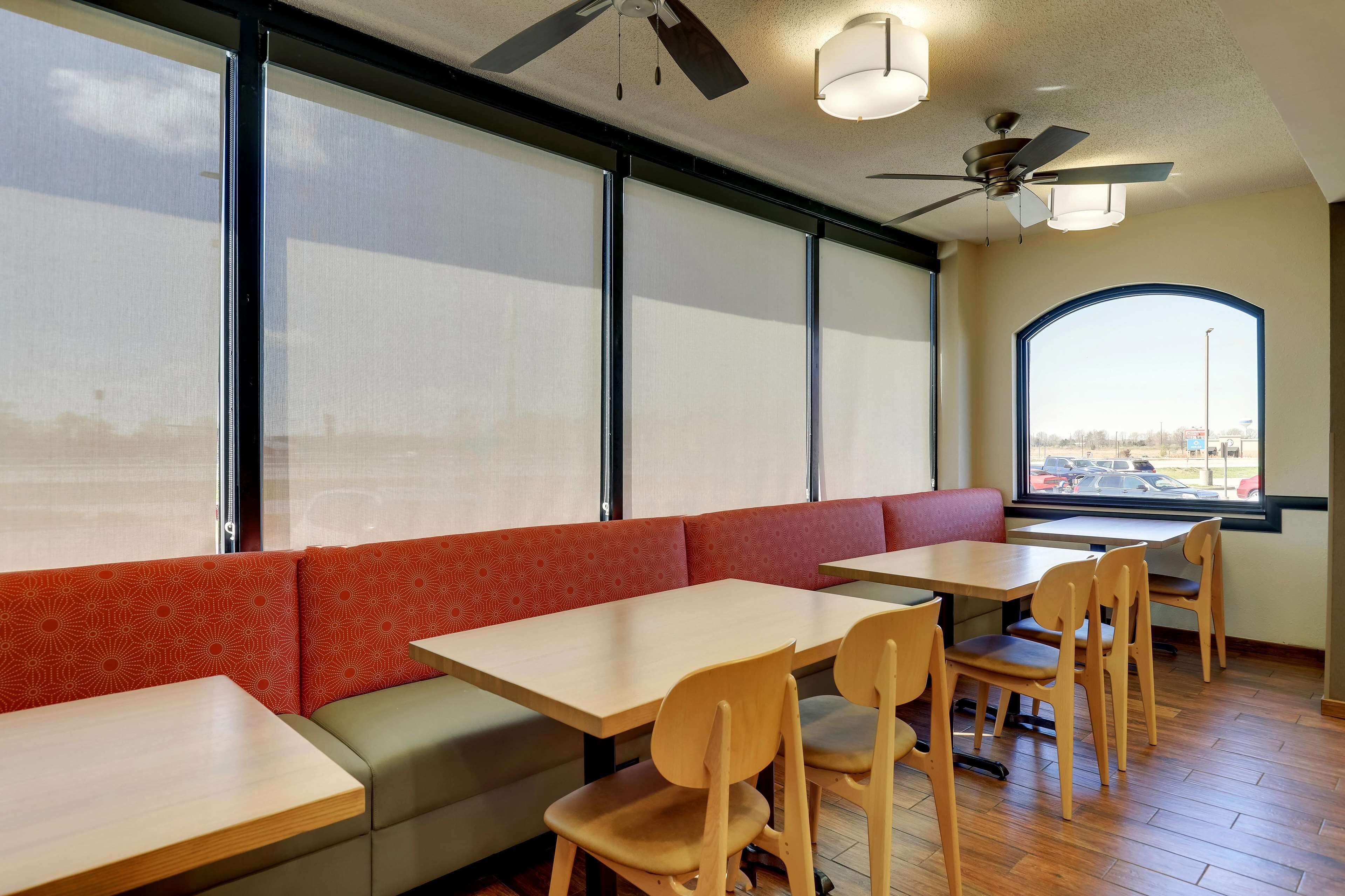 Un interior de restaurante con cabinas, mesas y sillas.