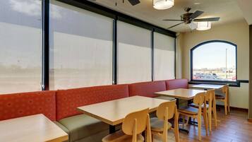 Un interior de restaurante con cabinas, mesas y sillas.