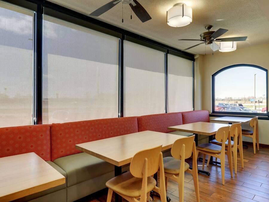 Un interior de restaurante con cabinas, mesas y sillas.