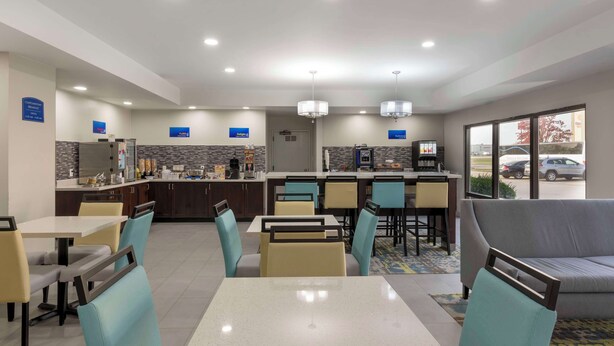 A hotel lobby with a dining area, kitchen, and seating. - Best Western Heartland Inn (Mattoon)