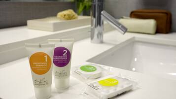 A bathroom counter with two bottles of Provitamin Shampoo and one bottle of Nourishing Conditioner, both dermatologist approved.