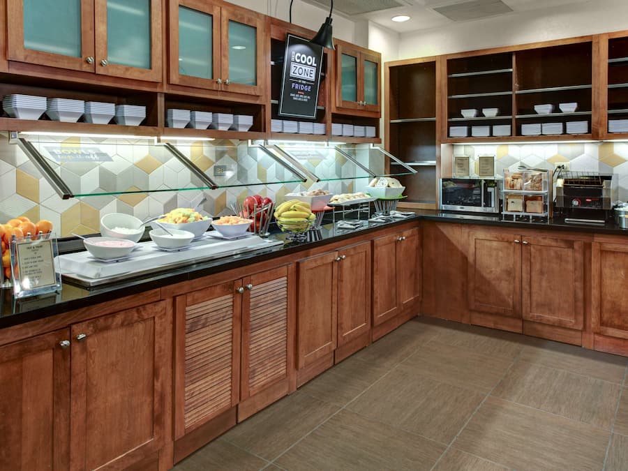 Un'area buffet con mobili in legno, una vetrina in vetro e diverse portate.