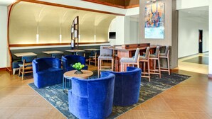 A lobby with seating areas, a reception desk, and a large screen. - Hyatt Place Itasca (Itasca)