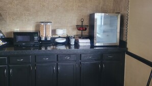 A kitchen with a microwave, a refrigerator, and a coffee station. - Days Inn by Wyndham Collinsville/St. Louis (Collinsville)