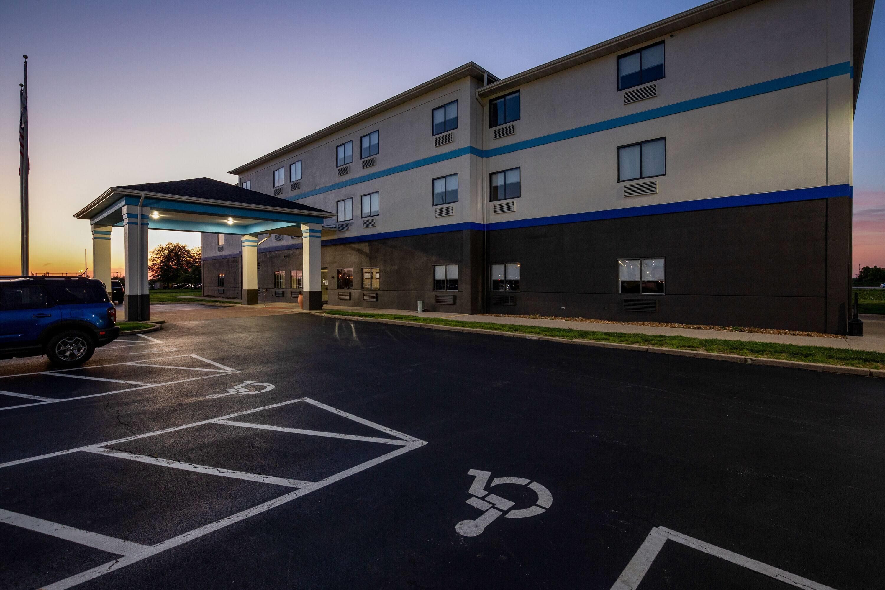 A modern building with a covered parking area and a blue-striped facade.