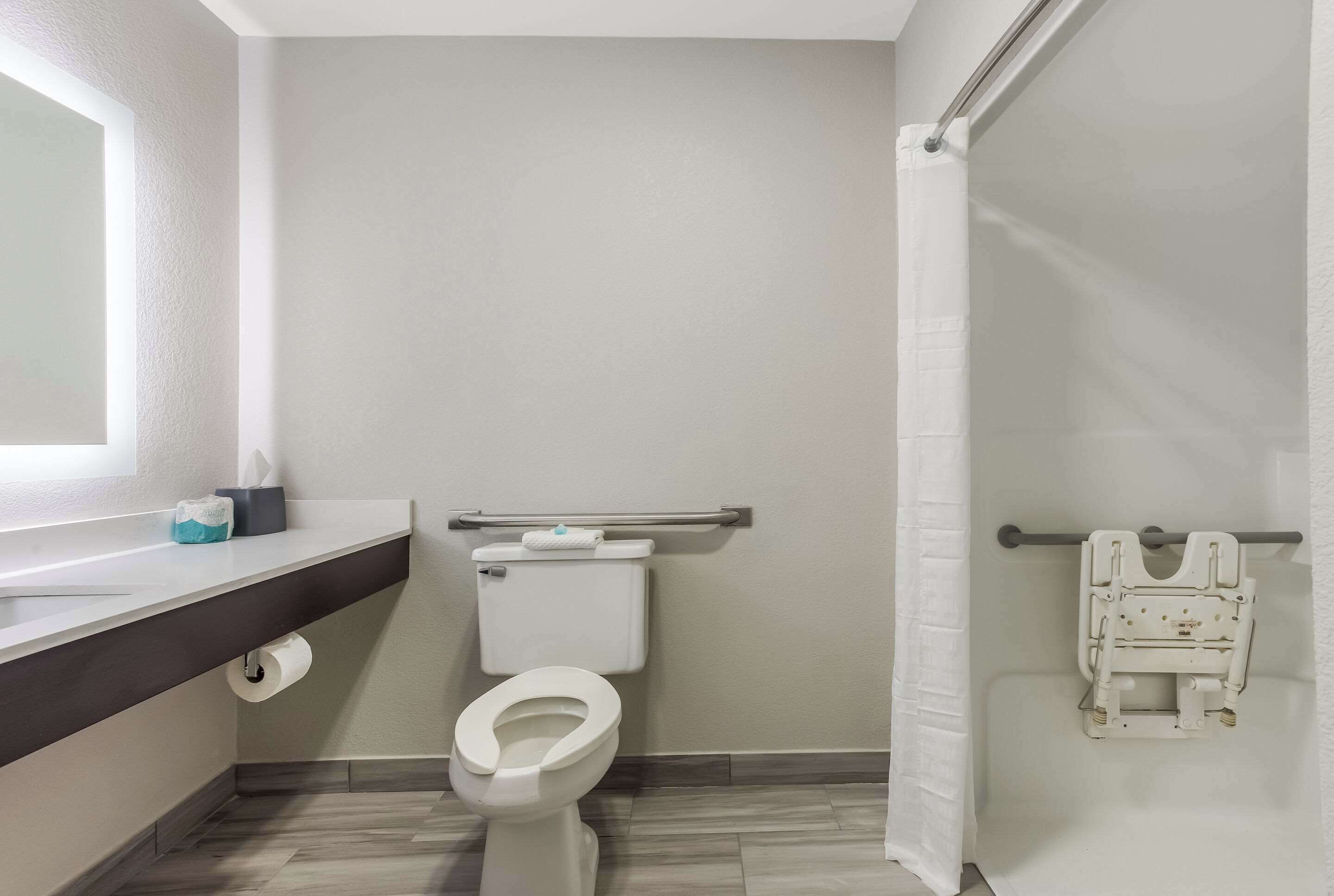 A bathroom with a toilet, a towel rack, and a shower curtain.