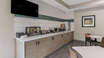 A modern kitchen with a flat-screen TV, a bread display, and a toaster.