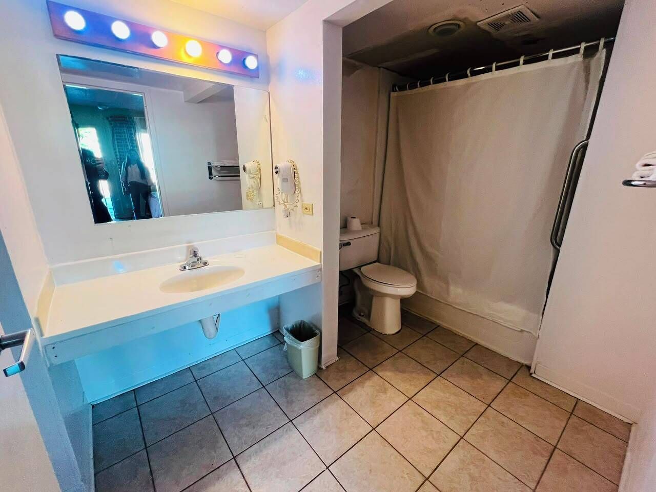 A bathroom with a sink, mirror, and toilet.