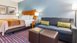 A hotel room with a bed, a sofa, a nightstand, and a patterned rug. - Comfort Inn Alton near I-255 (Alton)