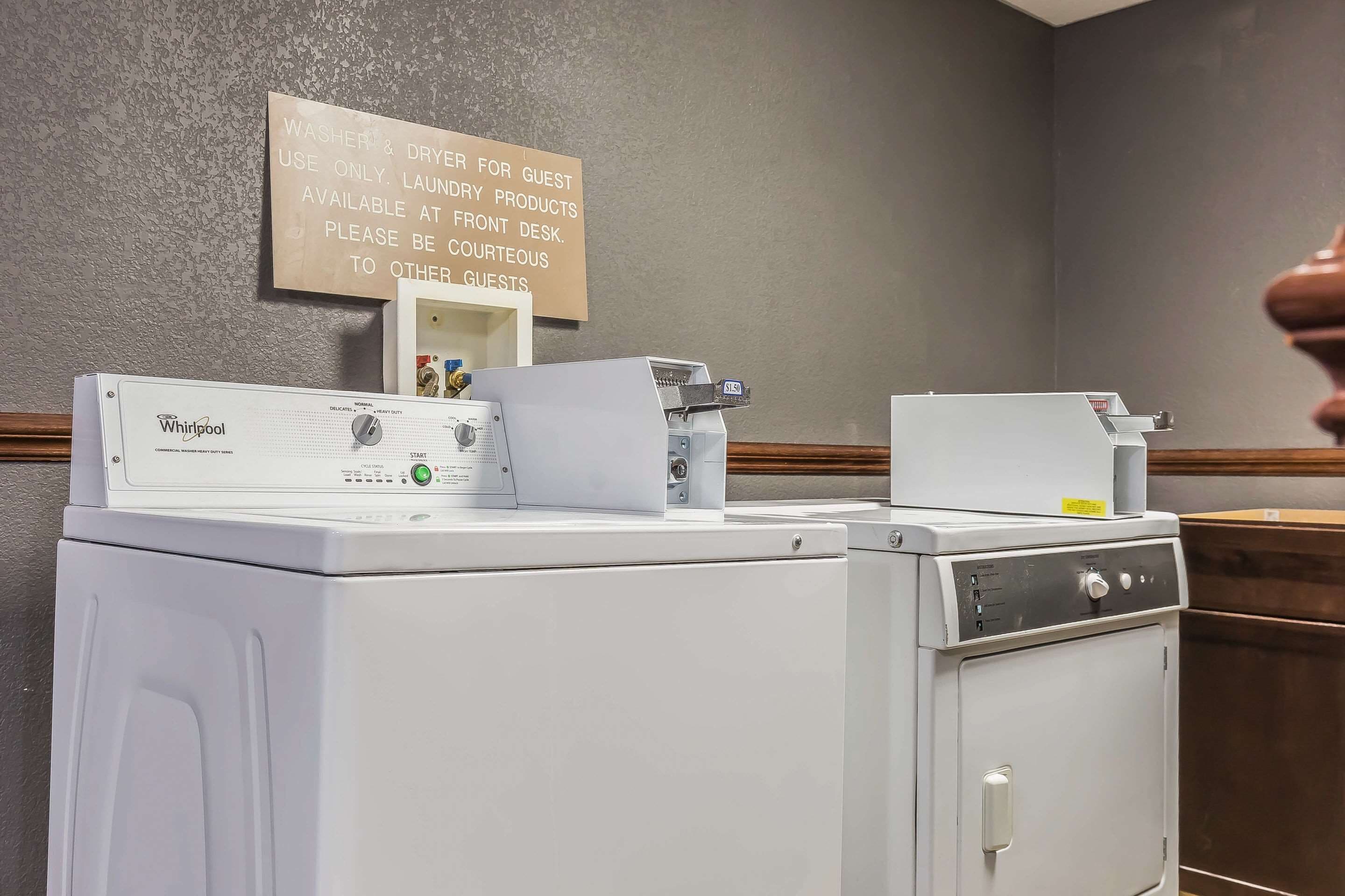 A laundry area with two Whirlpool washers and a sign instructing guests to use the dryers for their own products only.