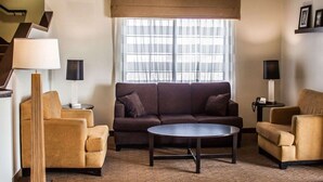 A modern living room with a sofa, two armchairs, a coffee table, and a large window with sheer curtains. - Sleep Inn Nampa near Idaho Center (Nampa)