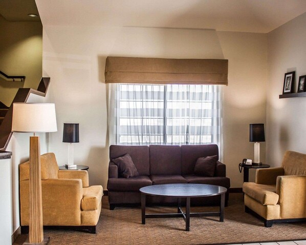 A modern living room with a sofa, two armchairs, a coffee table, and a large window with sheer curtains. - Sleep Inn Nampa near Idaho Center (Nampa)
