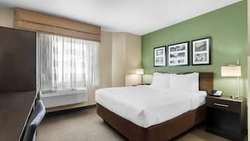 A hotel room with a bed, bedside lamps, a desk with a phone, and a window with curtains.