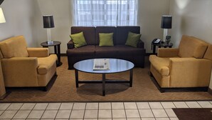 A living room with a brown sofa, two armchairs, a coffee table, and a window with sheer curtains. - Sleep Inn Nampa near Idaho Center (Nampa)