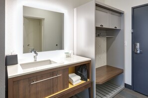 Une salle de bain moderne avec un lavabo blanc, un meuble-lavabo en bois et un miroir au-dessus du lavabo.