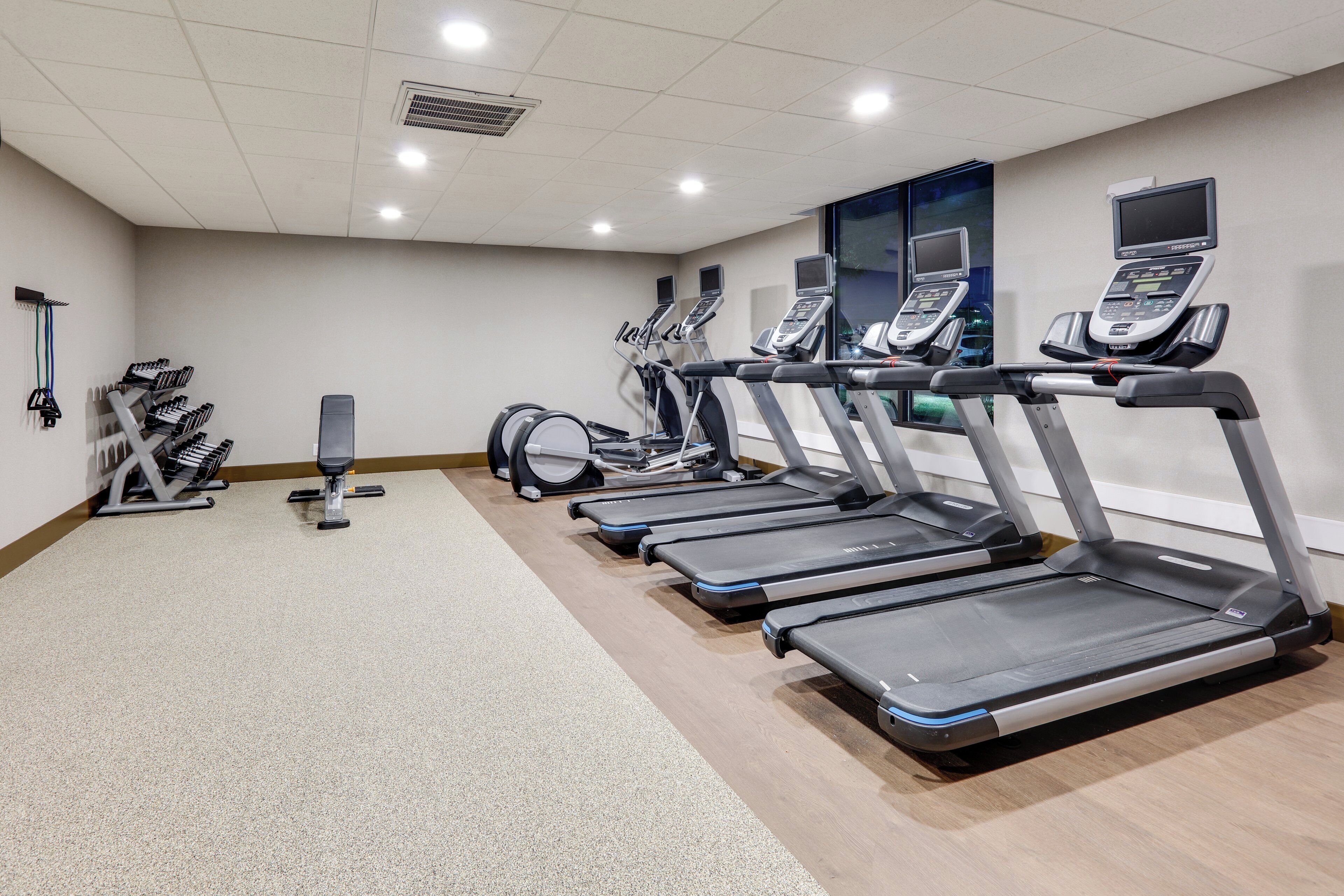 A gym with treadmills, weight machines, and a punching bag.