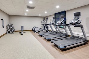 Un gimnasio con cintas de correr, máquinas de pesas y un saco de boxeo.