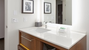 A modern bathroom with a white sink, a mirror, framed artwork on the wall, and a towel dispenser. - Holiday Inn Twin Falls by IHG (Twin Falls)