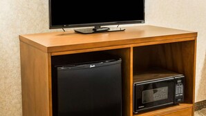 A wooden TV stand with a flat-screen TV, a mini fridge, and a microwave. - Quality Inn Lewiston (Lewiston)
