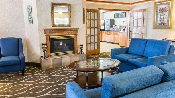A lobby with a fireplace, blue sofas, and a patterned carpet. - Quality Inn Lewiston (Lewiston)