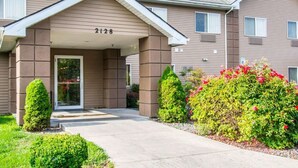 A two-story residential building with a covered entrance, numbered 2128, and a landscaped front yard with shrubs and flowers. - Quality Inn Lewiston (Lewiston)
