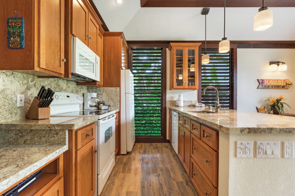 A kitchen with wooden cabinets, a granite countertop, a built-in oven, and a refrigerator.