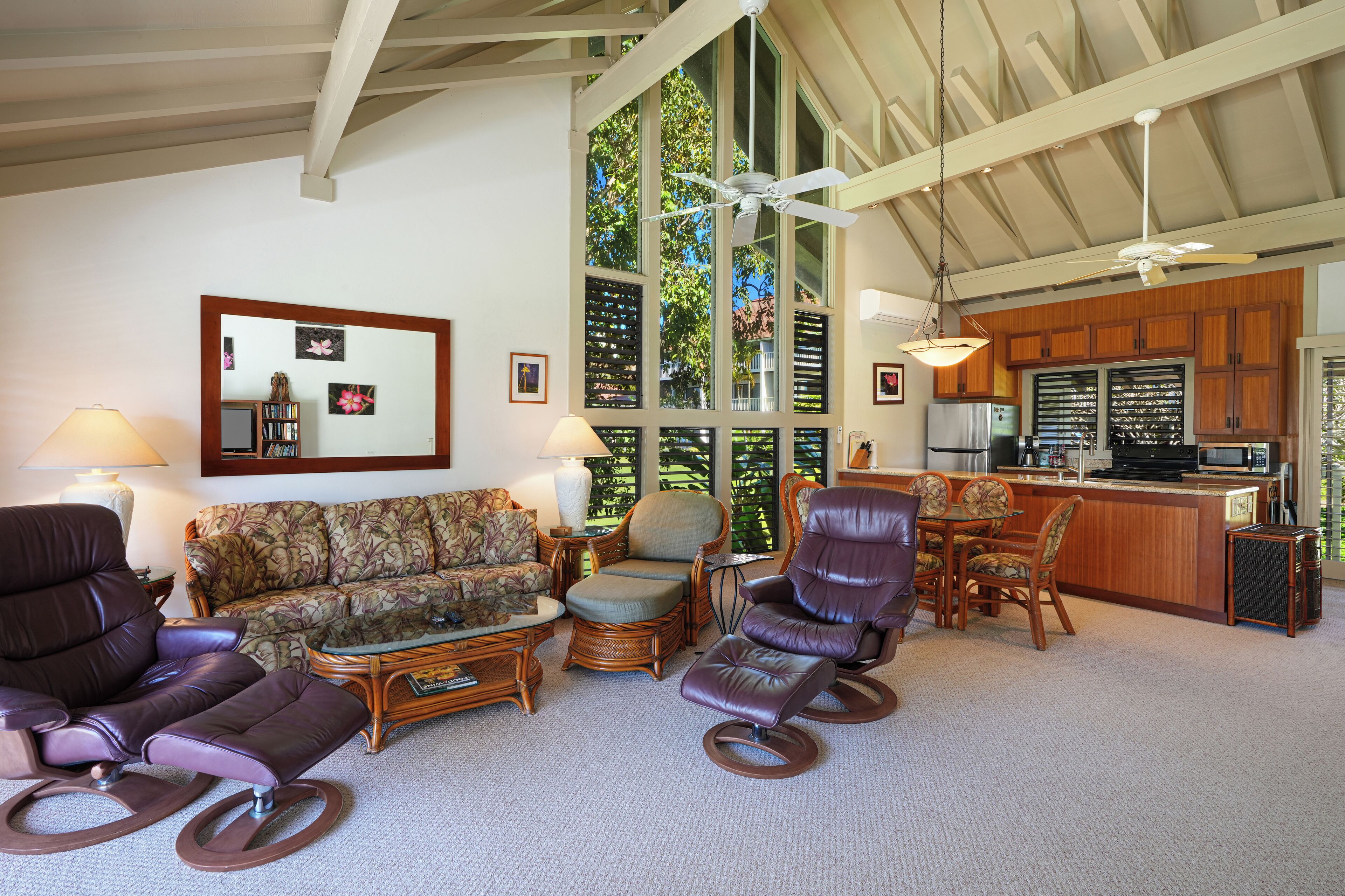 A spacious living room with a large window, a kitchen area, and a dining space.